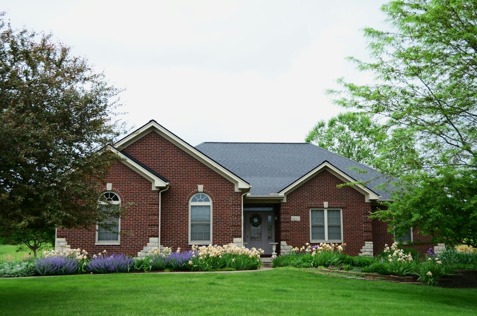 Ordinary suburban home with a tidy front lawn and garden bed
